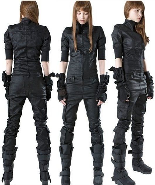 a composite image showing a woman modeling a black darkwear or goth jumpsuit with utility pants and combat boots. the image contains three views: back, front, and side profile. she is wearing fingerless gloves. the jumpsuit has a unique design with pockets and straps on the pants. her hair is long and straight.