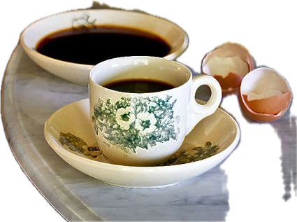a closeup shot of a white floral patterned teacup filled with black coffee sitting on a matching saucer. the cup is partially obscured by a partially visible eggshell and a full eggshell on the right side of the photo. there is a saucer with black coffee in the background. the cup and saucer are sitting on a marble table or tray, with a blurry white surface in the background. the coffee is in focus, while the rest of the image is slightly out of focus.