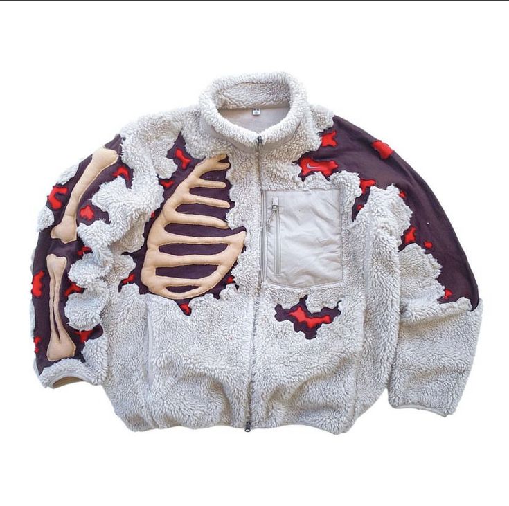 a white fleece jacket with a zipper closure and skeleton design on the front. the jacket is a full zip up with pockets on the chest. it is a warm and comfy jacket.