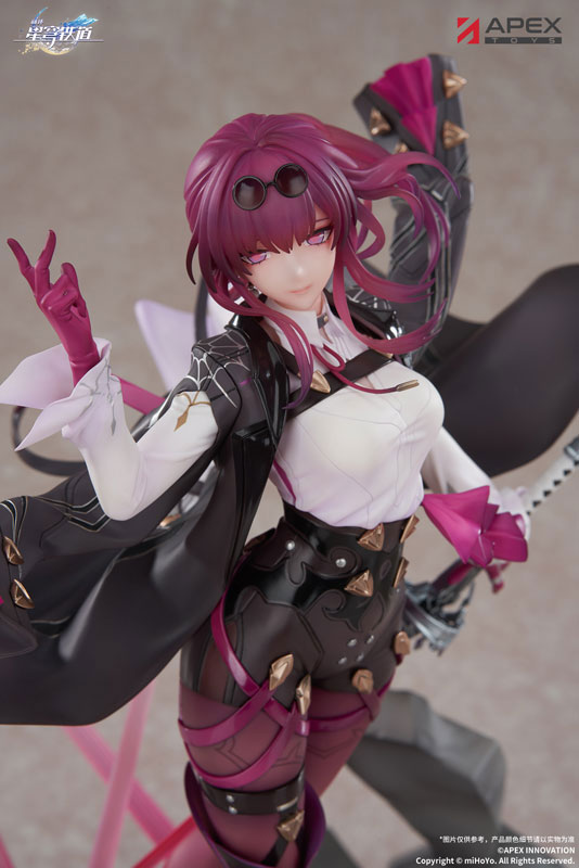 a detailed figurine of kafka from honkai star rail, produced by apex toys. she has magenta hair and is wearing a black and white outfit with gold accents. she is holding a sword and posing.