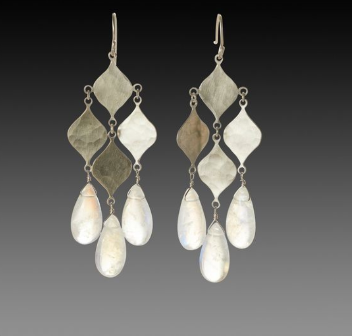 the image showcases a pair of elegant silver dangle earrings. each earring features three teardropshaped moonstones dangling from an arrangement of hammered silver diamonds. the earrings have a delicate and intricate design, highlighting the natural beauty of the moonstones.