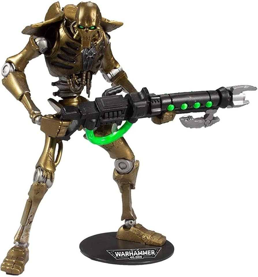 a golden necron warrior action figure from the warhammer 40,000 universe. the figure is holding a large black gun with glowing green parts. the figure stands on a black base with the warhammer 40,000 logo.