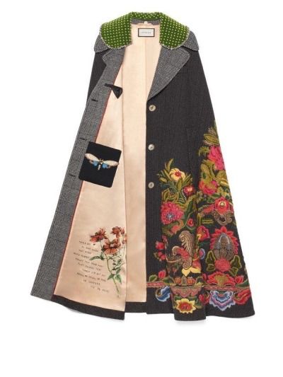 a gucci coat is shown, with floral embroidery on one side and writing and a floral design on the other. it has a green, polkadotted collar and a pocket with a moth on it.