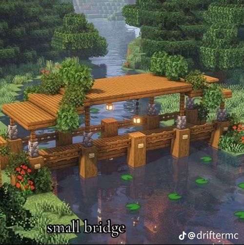 a screenshot from the game minecraft shows a small, covered wooden bridge over a body of water, likely a river or stream. the bridge is decorated with lanterns, greenery, and statues on the sides. the water features lily pads, and trees and vegetation are visible in the background. a text overlay at the bottom reads "small bridge" and the tiktok username "@driftermc".