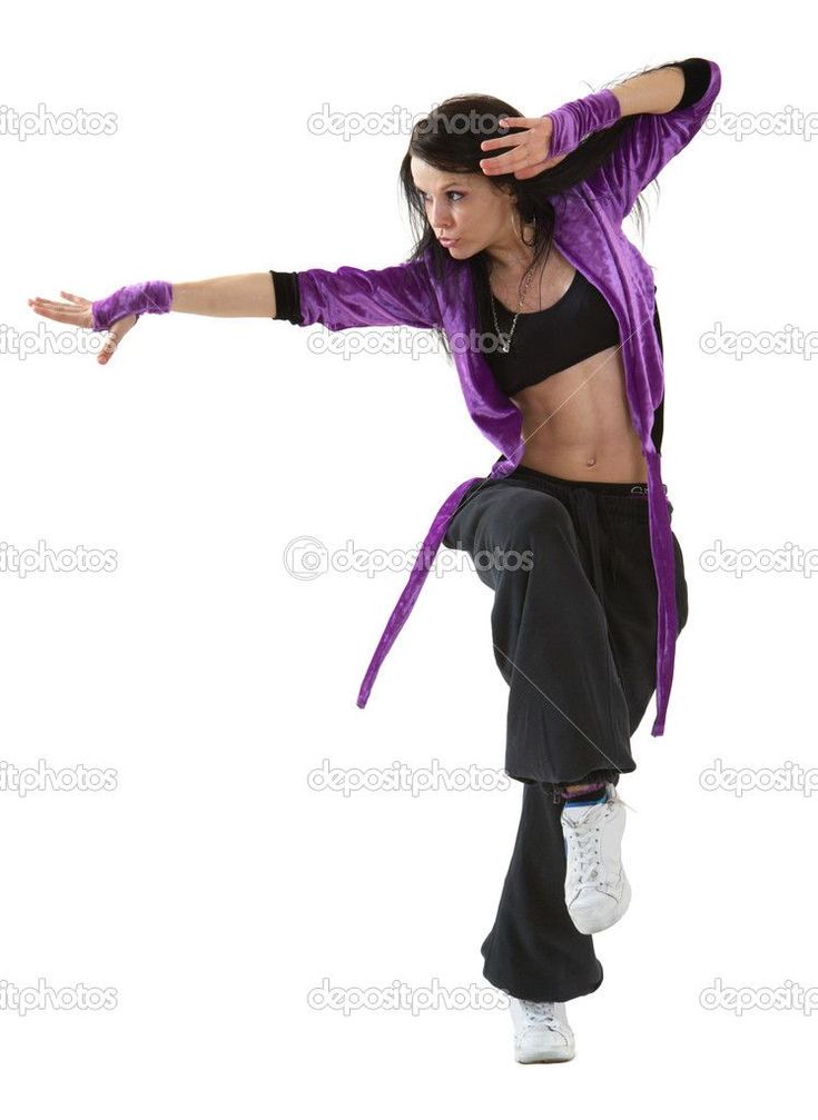 a young woman is dancing in a studio. she is wearing a purple top, black pants, and white sneakers. her hair is pulled back in a ponytail. she is moving her arms and legs in a graceful and energetic manner.