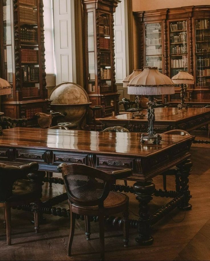 the image showcases a lavish, antique library.  the room is dominated by dark, richlystained wooden furniture.  tall, ornate bookcases filled with leatherbound books line the walls.  several large, intricately carved wooden desks are present, with antique lamps illuminating the surfaces. a large globe sits near one of the desks. the overall atmosphere is one of oldworld charm and elegance, suggesting a space for scholarly pursuits or quiet reflection. the dark wood tones and soft lighting create a warm, intimate feel. the chairs around the desks are also made of dark wood with intricate details. the flooring is dark wood, matching the furniture and adding to the richness of the overall ambience.