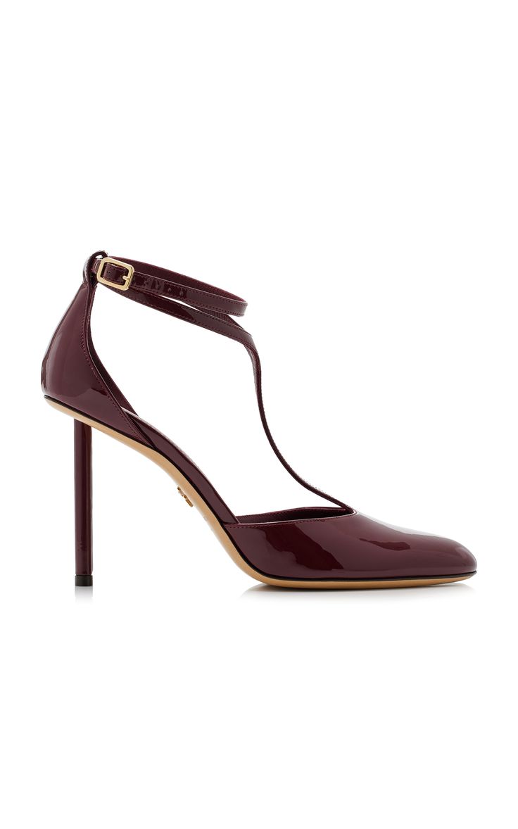 a closeup shot of a woman's burgundy leather heeled pumps with an ankle strap. the shoes are on a white background.