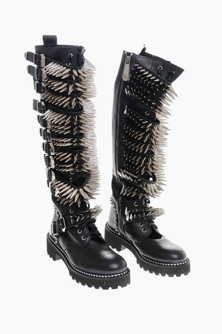 the image shows two black leather boots with silver spikes. the boots are tall, reaching up to the knee. the spikes are arranged in rows along the shaft of the boots. the boots have laces and buckles.