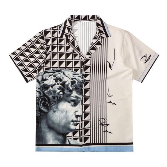 the image is of a shortsleeved buttondown shirt with a unique graphic design. the left side of the shirt features a repeating pattern of black triangles on a white background, with a greyscale depiction of michelangelo's david statue superimposed on the lower portion. the right side of the shirt is predominantly white with black vertical lines and abstract artistic elements resembling partial faces and curved shapes. a light blue band runs along the bottom hem of the shirt.
