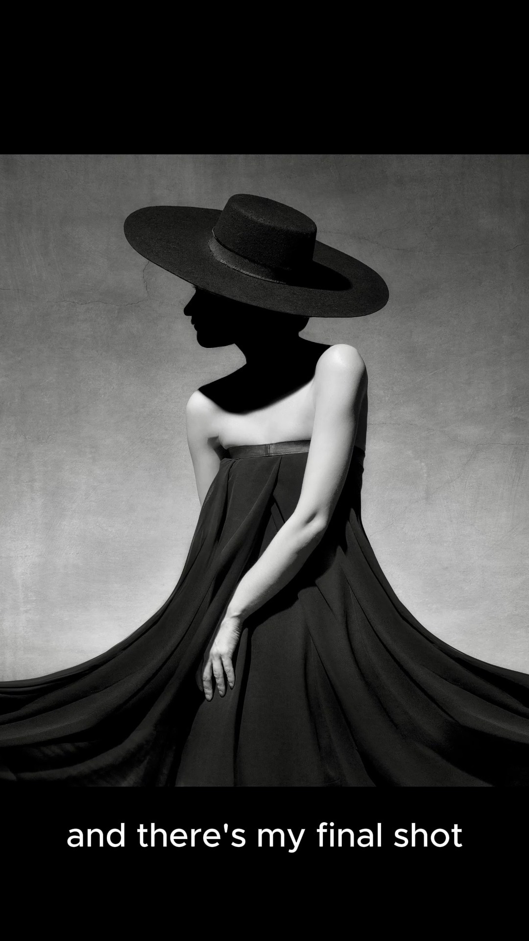 a woman in a black dress and hat stands against a white background, creating a striking silhouette. the image is in black and white, which adds to the mysterious and elegant atmosphere. the woman's pose is dramatic and the lighting highlights the shape of her body and dress. the overall effect is one of timeless beauty and sophistication.