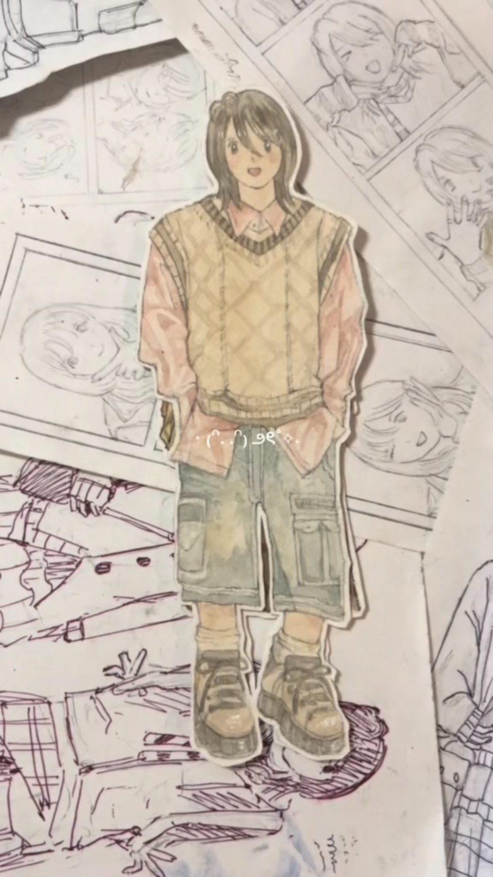 the image shows a watercolor illustration of an animestyle character. the character is a young man with shoulderlength brown hair and is wearing a stylish outfit consisting of a light brown vest over a pink collared shirt, loosefitting kneelength shorts with large pockets, and brown boots. the background features several sketches of other anime characters, suggesting a creative workspace or design process. the illustration is drawn with a soft and delicate touch, capturing a sense of youthfulness and gentle demeanor.
