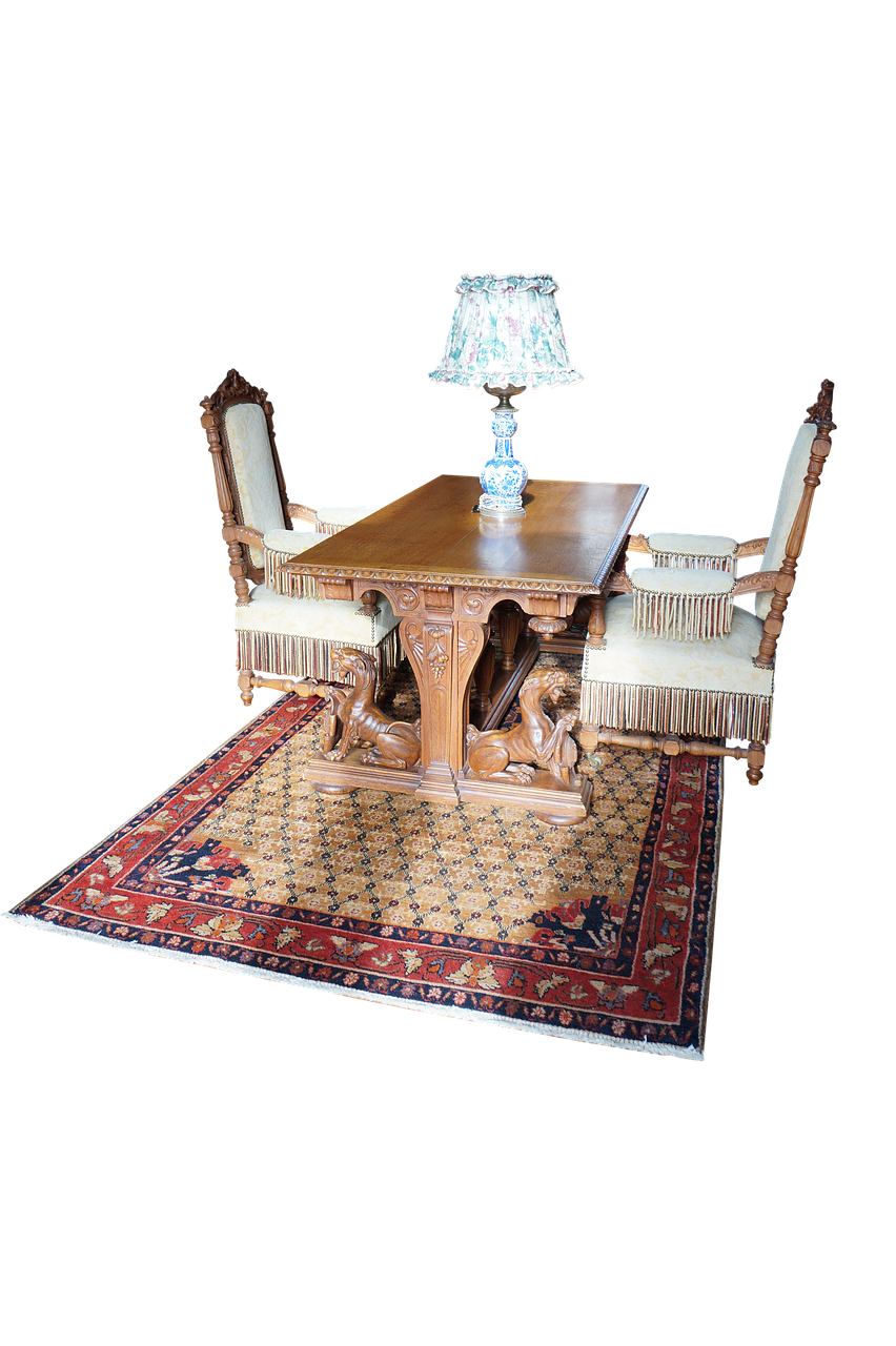 the image features a welllit antique table with two ornate chairs and a lamp on top, all placed on an oriental rug. the table is decorated with carved lion statues supporting the legs. the chairs feature intricate wooden frames with lightcolored cushions and fringe. the lamp has a floral patterned shade and sits centrally on the table. an oriental rug with intricate designs and a red and blue border is under the furniture. the background is a solid black.