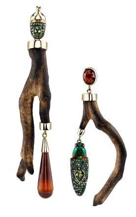 two elaborate earrings are displayed on a white background. the left earring features a brown branchlike shape with gold accents and an acorn detail at the top, finished with a brown teardrop pendant. the right earring has a similar branch structure with a red gem at the top and a decorative cicada pendant.