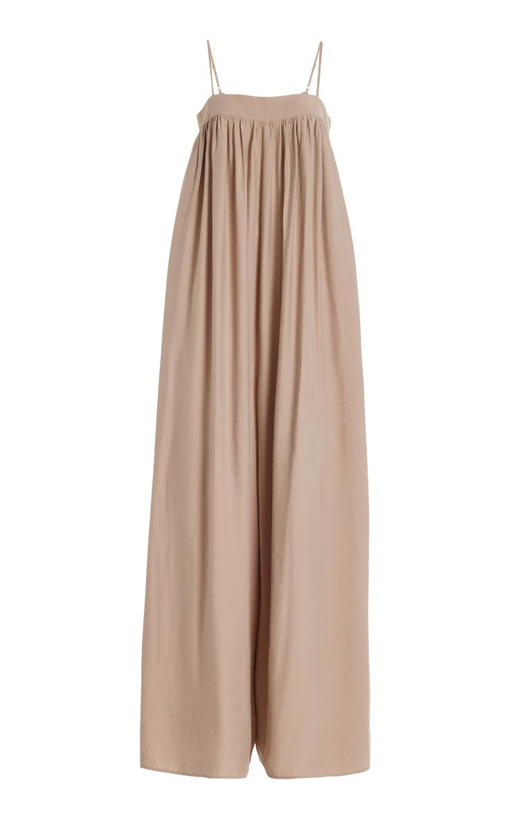 a beige sleeveless maxi dress with a flowy, loose fit. it has a simple, elegant design and is perfect for a summer party or event. the dress is made of a soft and comfortable fabric that feels great against the skin. it's a chic and relaxed look that's perfect for any occasion.