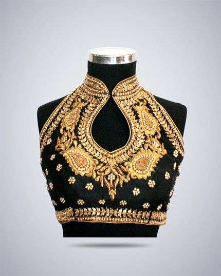 a black, heavily embroidered halter neck blouse is displayed on a mannequin. the blouse features intricate gold embroidery around the neckline, shoulders, and hem. the design includes paisley patterns and small floral accents. the background is a gradient gray.