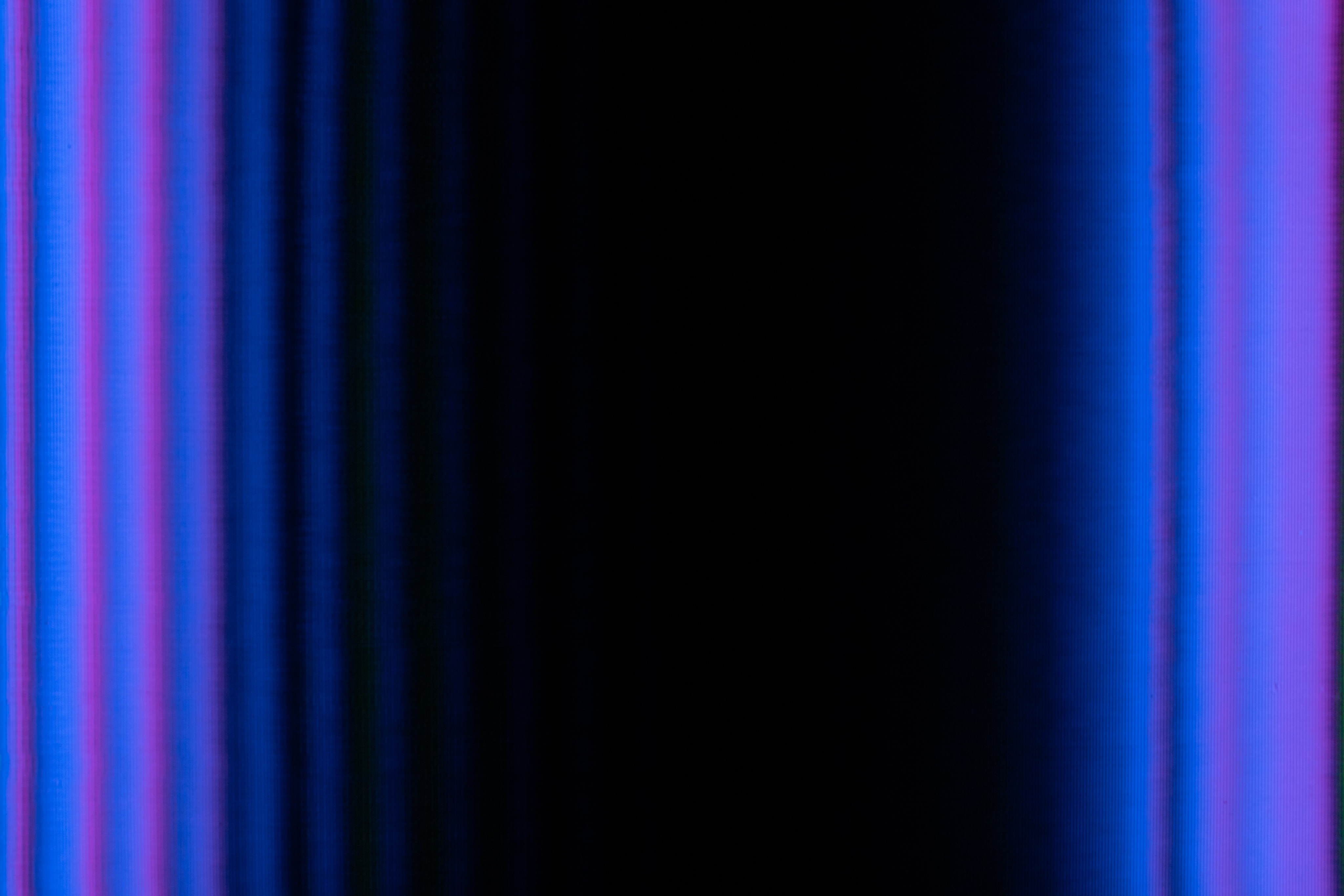 an abstract image of gradient blue and purple vertical lines with a black background.