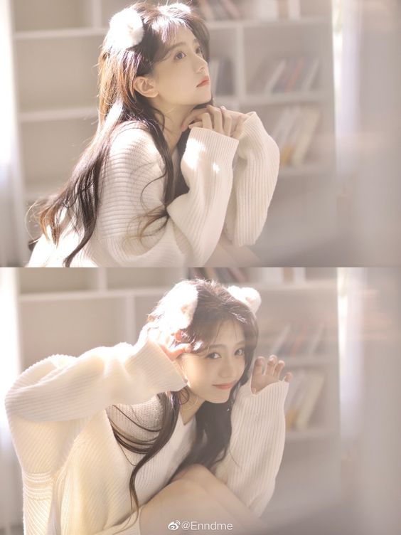 he image features a young woman with long brown hair wearing a white, fuzzy sweater and a white cat ear headband. she is posing indoors in a room with a bookshelf visible in the background. the lighting is soft and natural, likely coming from a window offcamera. the woman is depicted in two different poses, both highlighting her beauty and youthful charm. in the top image, she gazes off to the side with a dreamy expression. in the bottom image, she looks directly at the camera with a playful, coy smile.