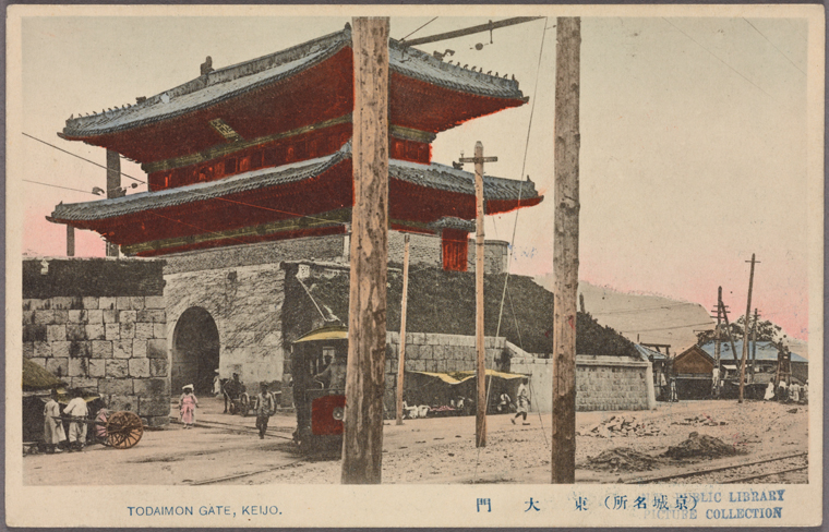 the image shows the todaimon gate in keijo (presentday seoul), with traditional japanese architecture, including a multitiered gate structure. people are seen walking on the street. a tram can be seen with tracks on the right. the image has a vintage postcard appearance, suggesting it is a historical image.