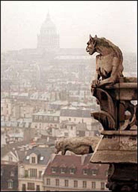 a gargoyle statue perched on a rooftop overlooking a cityscape. the gargoyle is a stone sculpture of a grotesque creature, with a wide open mouth and a twisted body. the statue is weathered and worn, with moss and lichen growing on its surface. in the background, the city of paris is shrouded in a hazy fog, and the iconic notre dame cathedral can be seen in the distance. the image captures the beauty and mystery of medieval architecture.