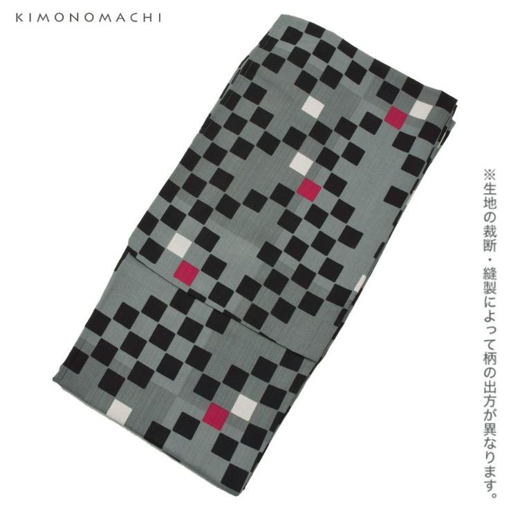 the image shows a folded piece of patterned fabric, likely a kimono obi or similar textile. the fabric has a geometric checkered design with gray as the base color, overlaid with black, red, and white squares. the design appears to be a modern take on a traditional japanese pattern. the top left corner of the image contains the brand name "kimonomachi". on the right side, there is a vertical japanese text that states that the pattern layout may vary depending on the cutting and sewing of the fabric.
