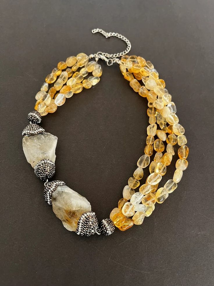 a beautiful citrine necklace made with natural stones, featuring a multistrand design with a unique chunky citrine pendant and silver accents.