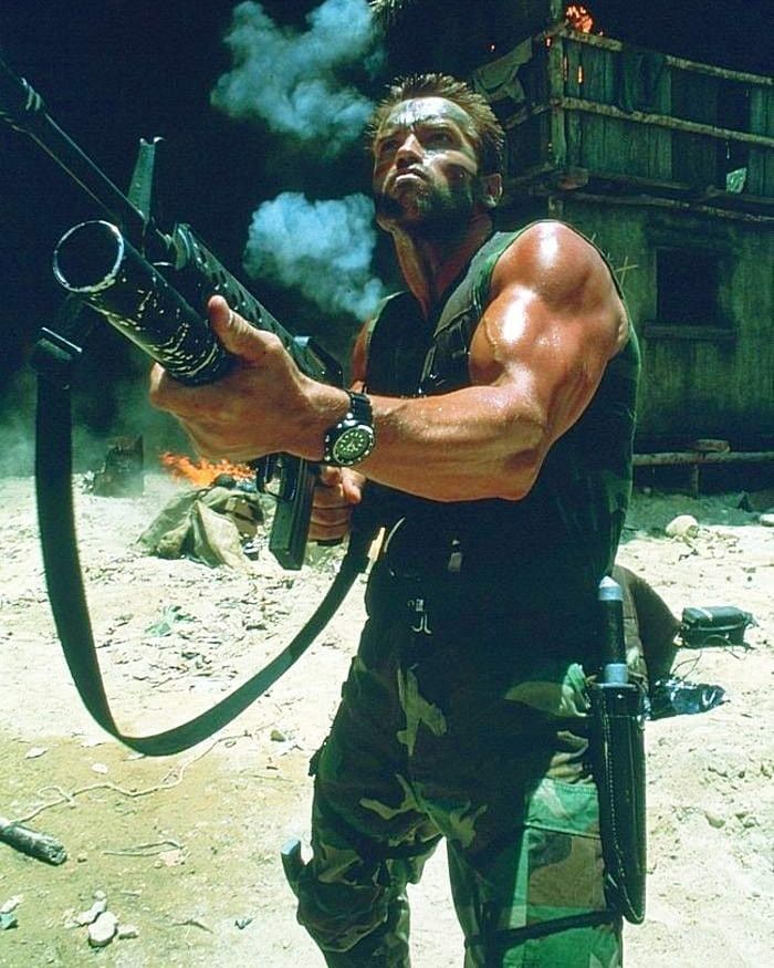 a soldier with a grenade launcher in his hands, wearing camouflage uniform, during a battle. the scene is set against a backdrop of a wooden structure, with smoke and dust in the air.  this image captures the intensity of warfare.