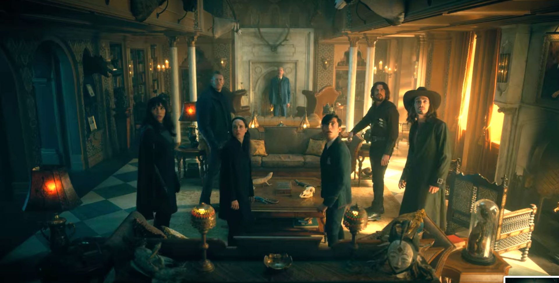 the image shows a group of seven people gathered in a grand, dimly lit room. the atmosphere is heavy with suspense.  the room is cluttered with eclectic furniture and objects with an occult theme, including animal skulls, candles, and strange artifacts. the people are dressed in dark, modern clothing and most are standing with serious expressions, suggesting they are facing a serious or mysterious situation.  the warm, lowkey lighting casts dramatic shadows and enhances the feeling of mystery.