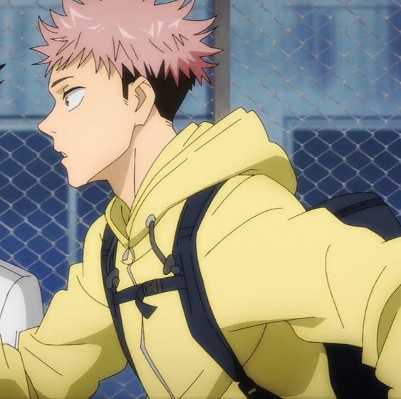 this is an animestyle drawing of a young man with spiky pink hair. he is wearing a yellow hoodie and carrying a black backpack. the setting appears to be a city street, as indicated by the chainlink fence in the background. the lighting is bright and sunny, suggesting daytime. the perspective is a closeup side view, emphasizing the man's profile and expression.
