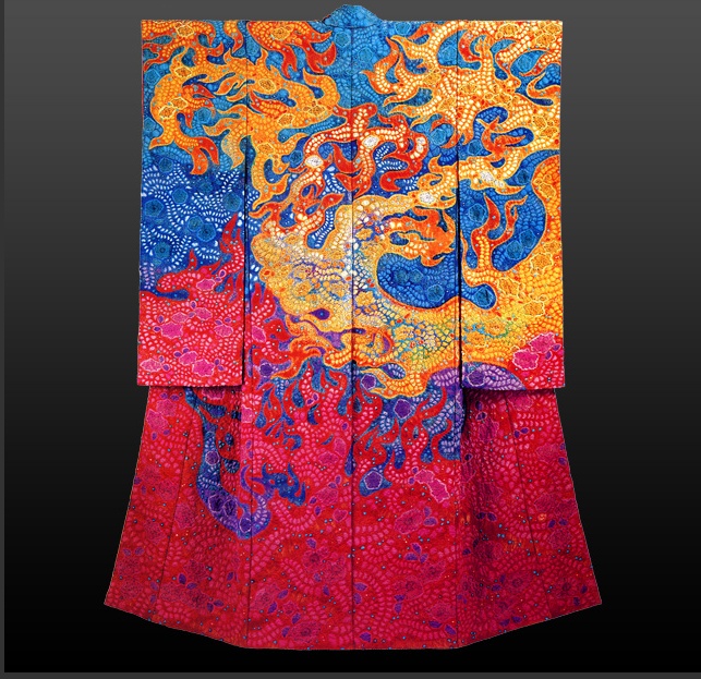 the image shows a fulllength view of a colorful and intricately designed kimono. the garment features a vibrant palette of orange, blue, and red, with an abstract pattern that gives the impression of stylized flames or organic forms. the textile art showcases a detailed and artistic pattern, typical of japanese cultural attire, but with a modern or contemporary interpretation. the background is dark, emphasizing the vibrant colors and detailed design of the kimono.