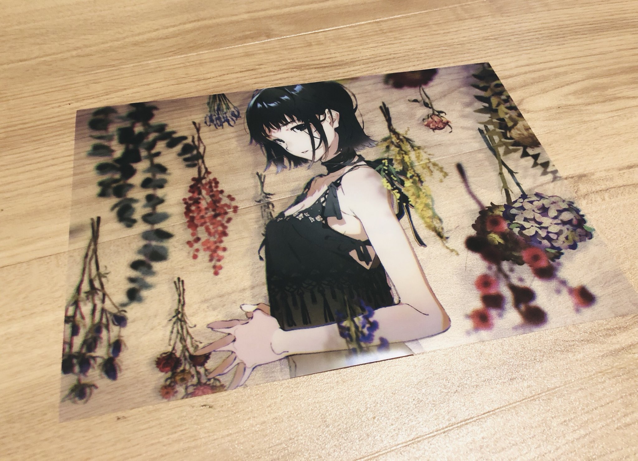 an anime illustration featuring a girl with short black hair and a black dress standing in a room. she's reaching out with her hand towards the viewer, surrounded by various hanging dried flowers.