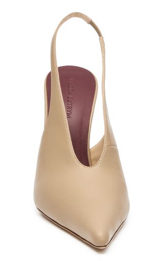 a pair of women's nude leather slingback pumps with pointy toes. the shoes are made by a designer label and are  elegant and stylish.