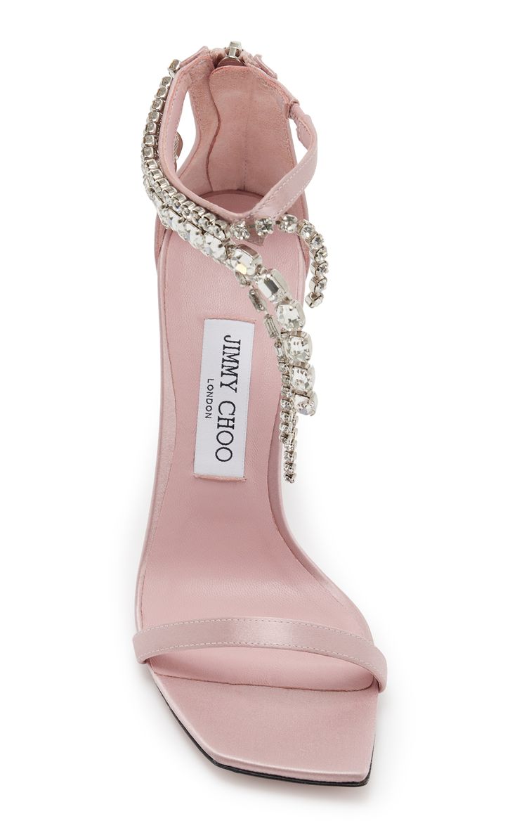 a pair of jimmy choo london pink satin high heels with crystal embellishments are shown on a white background.  the shoes feature an ankle strap and a square toe.  the jimmy choo logo is visible on the insole.