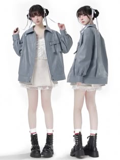 two girls are wearing grey jackets and white skirts. both are wearing black boots and standing side by side, looking away from the camera. the girl on the left has her hair pulled back, while the girl on the right has her hair loose. they are both smiling.