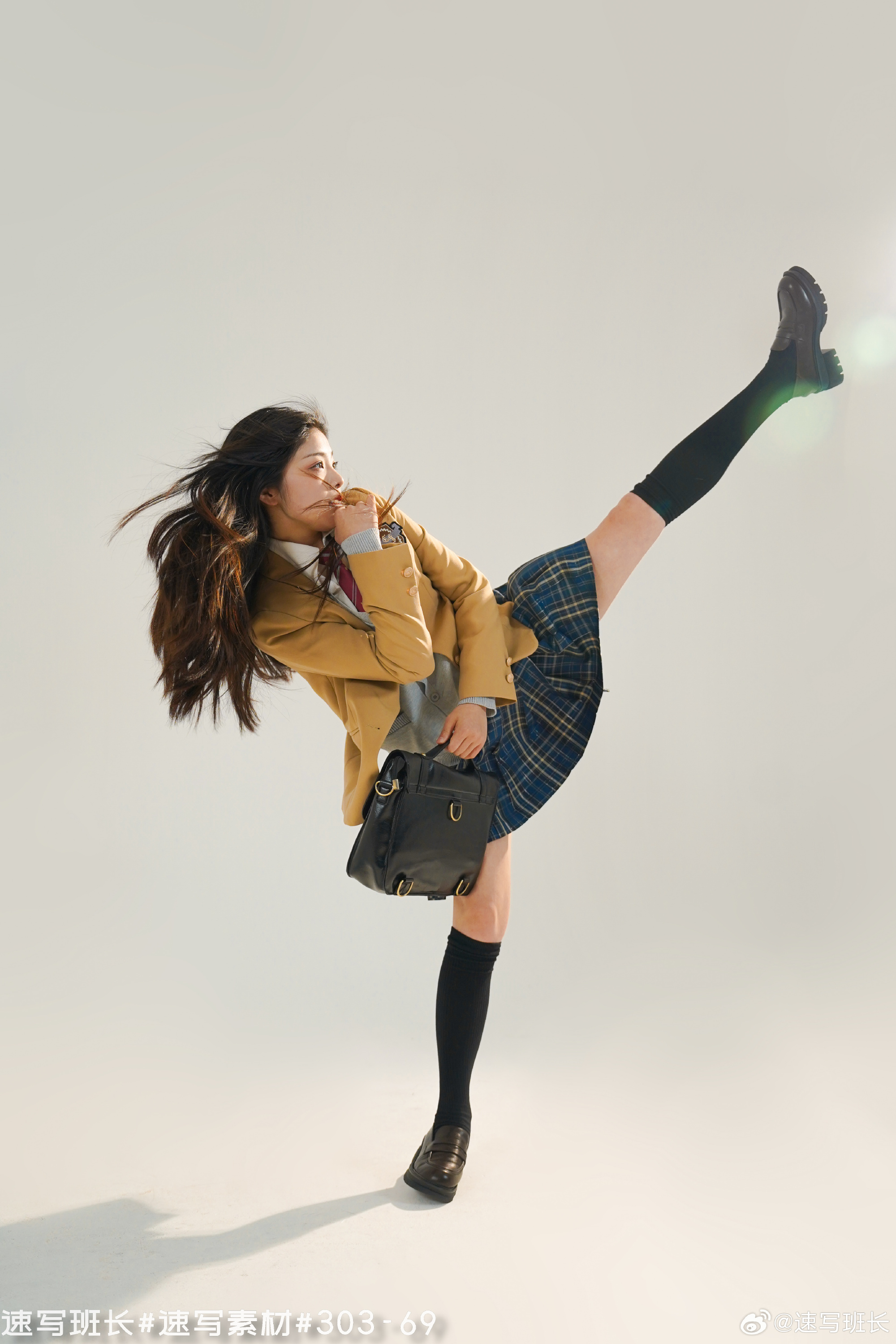a young woman in a yellow and blue school uniform is captured midair, executing a powerful high kick. her long black hair flows behind her as she confidently strikes a pose. the background is a clean, bright white, highlighting the dynamic movement of the woman.