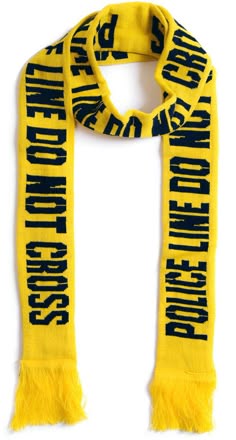 a yellow knitted scarf with black text that reads "police line do not cross" on both sides. the scarf has fringe at the ends.