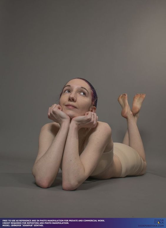 woman with purple hair is lying on her stomach on a gray background. she is looking up with her chin resting on her hands. the image is a reference photo for artists and photo manipulators.