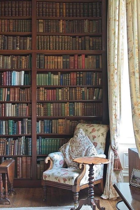 the image showcases a cozy reading nook within a classic library setting. a large, floortoceiling bookcase dominates the wall, packed with rows upon rows of antique books. a plush armchair with a floral pattern sits invitingly beside it, accompanied by a small round table. soft, natural light streams in from a window veiled in delicate floral curtains, casting a warm glow over the scene.  the overall ambiance is one of tranquility, history, and the pursuit of knowledge.