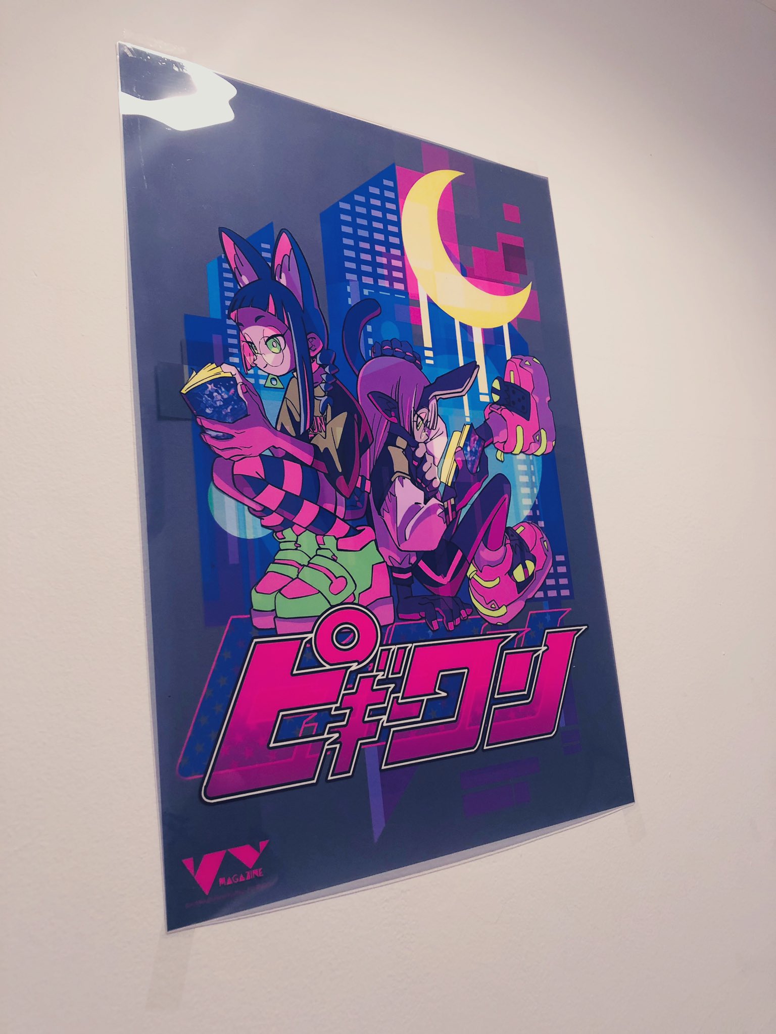 a poster featuring two stylized female characters with catlike features against a dark, neonlit cityscape backdrop. the characters are dynamically posed, suggesting action and attitude. the overall aesthetic is a blend of cyberpunk and anime influences.  the poster's text and visual elements have a japanese theme.