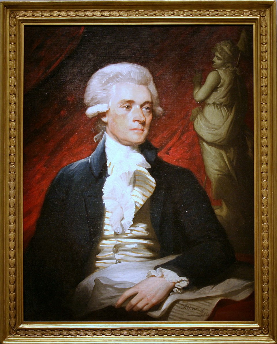 the image is a framed portrait painting of thomas jefferson. he is depicted from the chest up, wearing a dark jacket, a striped vest, and a white ruffled shirt. his white powdered wig is neatly styled. in the background, a red curtain and a white statue of a woman holding a flag can be seen. the painting is encased in an ornate gold frame.