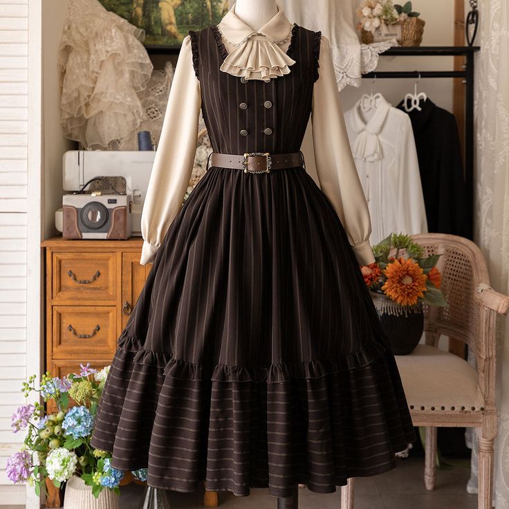 the image showcases a brown and beige striped vintagestyle dress displayed on a mannequin.  the dress features a doublebreasted bodice with a brown belt and a full, ruffled skirt. the mannequin is also adorned with a white blouse and a bow tie.  the setting includes a vintage sewing machine, a bouquet of flowers, and antiquestyle furniture, adding to the vintage aesthetic of the image.