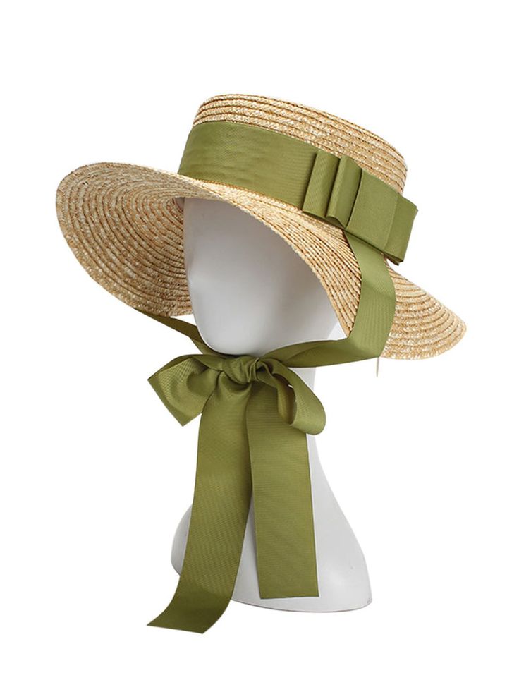 a widebrimmed straw sun hat with a large green ribbon tied around the crown in a bow. the hat is shown on a white mannequin head, against a white background. the hat is angled slightly to the side.
