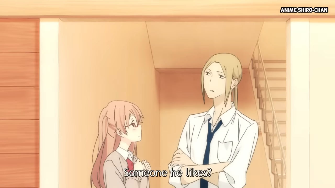the image shows a conversation between a tall, slender man and a shorter woman in glasses.  the man has light hair tied back, while the woman has pink hair. the woman is wearing a pink and white school uniform. the man has a more neutral outfit with a white shirt and blue tie. the environment suggests they are inside a house or school building, with a staircase visible in the background. the lighting is soft and warm, creating a gentle atmosphere.