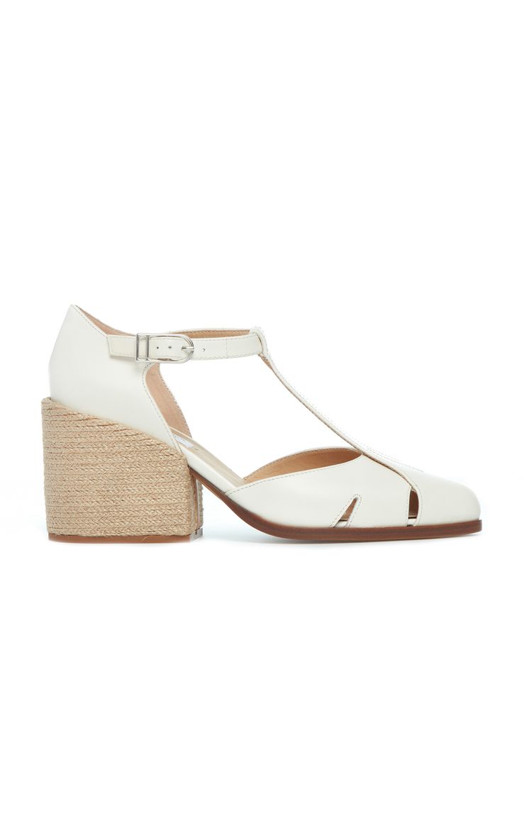 a pair of women's white tstrap shoes with a block heel made of espadrille material. the shoes have a cutout design on the upper and an ankle strap. they are a summery style that would be appropriate for a wedding or other special occasion.