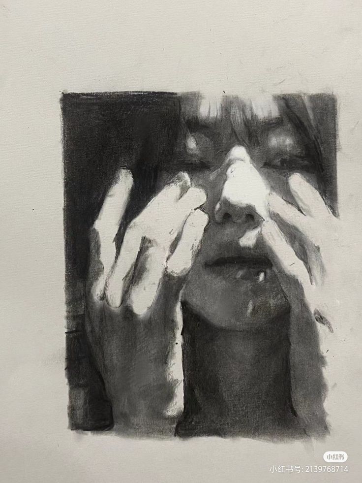 the image is a charcoal drawing of a person's face. the subject's hands are covering their face, obscuring much of their features.  the drawing is highly expressive, utilizing strong contrasts between light and dark to create a moody and intense atmosphere. the style is realistic but with a focus on emotional impact rather than minute detail. the overall tone is dark and somber, hinting at possible feelings of anxiety, sadness, or selfconsciousness.  the charcoal technique effectively conveys texture and depth.