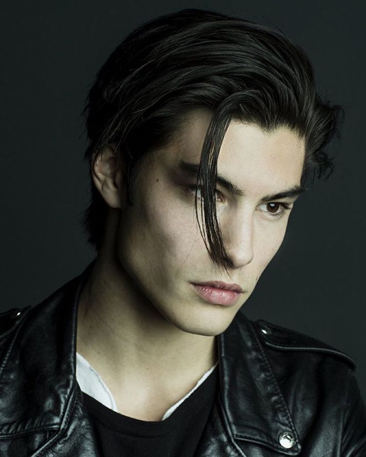 a portrait of a handsome man with dark hair wearing a leather jacket.
