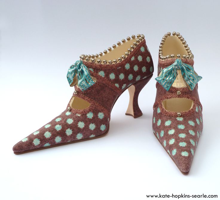 a pair of high heel shoes with brown fabric, a teal colored polka dot pattern, and teal bows.  they are sitting on a white surface.