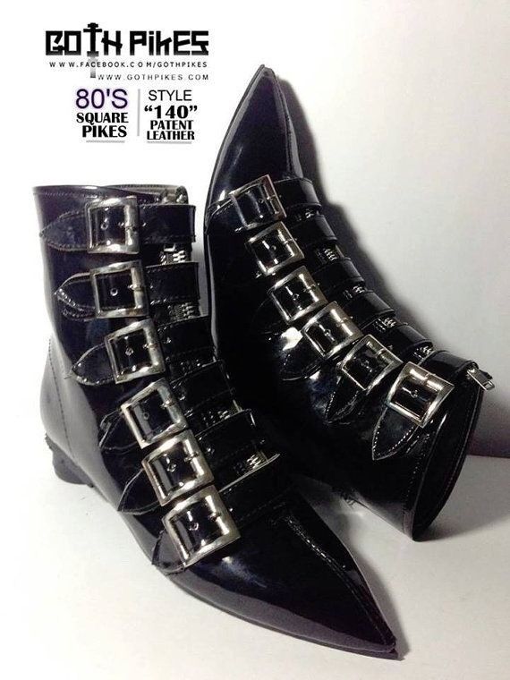 the image shows a pair of black patent leather boots with multiple buckles, reminiscent of 80s goth style. the boots have a pointed toe and are labeled as "square pikes." the brand "goth pikes" is also visible.