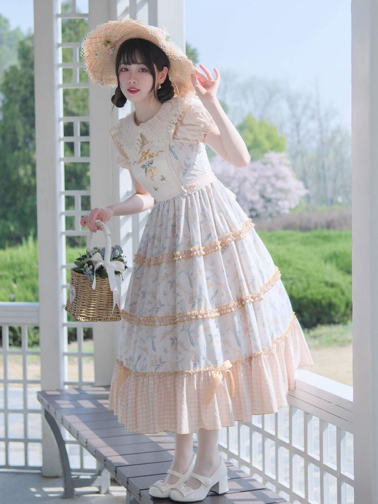 a young woman in a stylish lolita fashion dress is posing outdoors in a gazebo. she is wearing a white and yellow floral dress, a straw hat, and white shoes. she is holding a picnic basket and smiling softly at the camera. the image evokes a sense of femininity, elegance, and springtime joy. the soft, natural lighting enhances the overall dreamy and romantic feel.