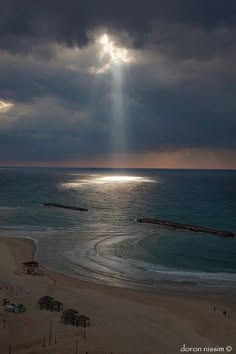 a serene image of a beach with clear blue water and sunlight shining through the clouds, casting a beam of light on the ocean. the scene is peaceful and tranquil, with soft, gentle waves lapping at the shore.