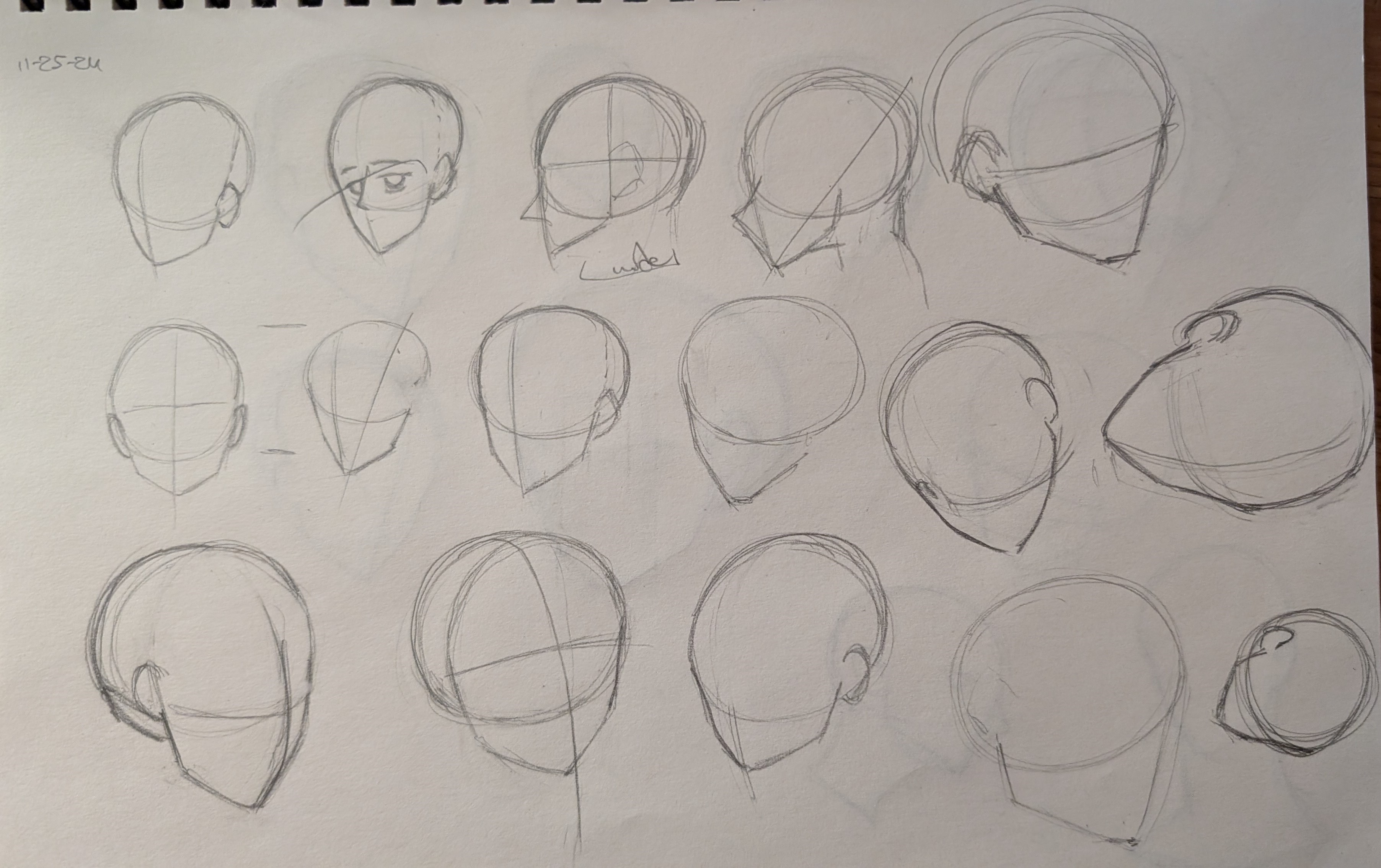 the image contains a collection of pencil sketches focusing on the practice of drawing heads from various angles and perspectives.  the sketches range from simple basic shapes and construction lines to more detailed outlines of faces, suggesting an artist's practice in head anatomy and form.  some sketches show simple, almost geometric shapes, while others start to incorporate features suggesting an anime or manga style.  the sketches appear to be done on notebook paper.